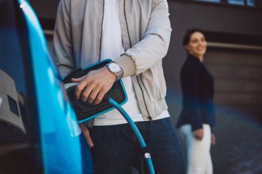 Çift yeni elektrikli arabalarını şarj ediyor.