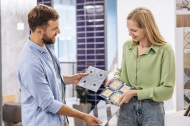 İnşaat pazarındaki genç çift fayans seçiyor.