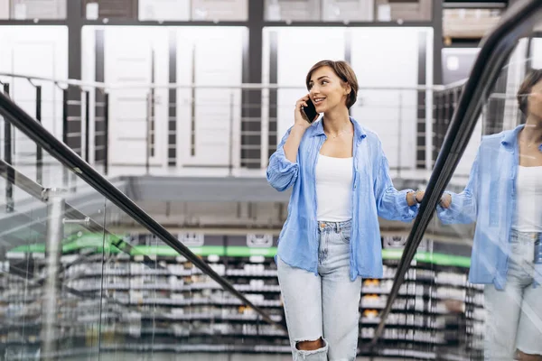 Yürüyen Merdivendeki Kadın Malzeme Deposunda Telefonuyla Konuşuyor — Stok fotoğraf