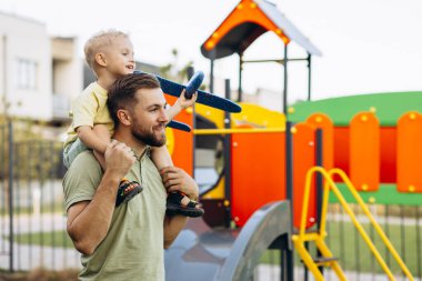 Baba ve oğlu oyuncak uçakla oynuyorlar.