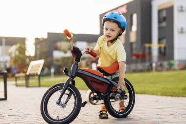 Bisiklet sürmeyi öğrenen sevimli küçük çocuk.