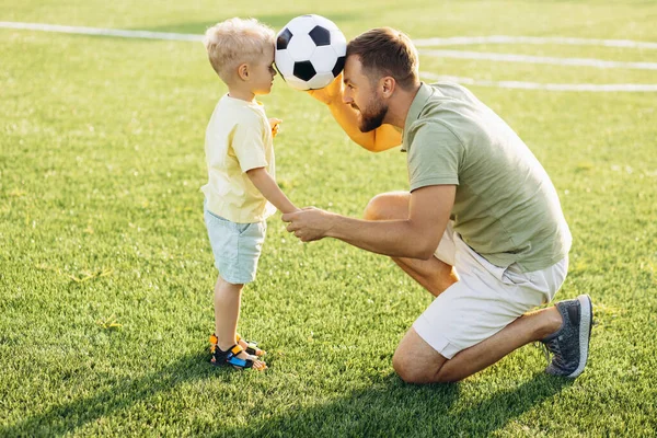 Father with son playing football at the football field