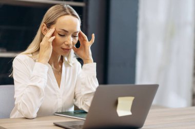 Dizüstü bilgisayarda çalışan fayanslı bir kadın.