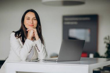 Araba galerisinde dizüstü bilgisayarda çalışan bir iş kadını.