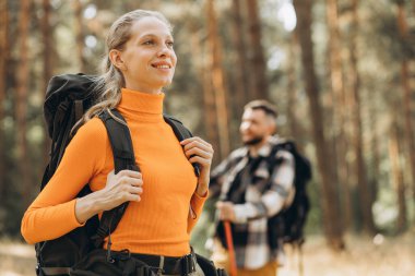 Çantalarla yürüyüş yapan ve ormanda yürüyen çiftler.