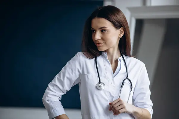 Young woman doctor in lab coat with stethoscope