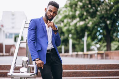 Mavi ceketli Afrikalı Amerikalı.