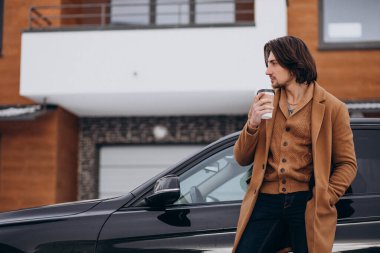 Genç yakışıklı adam kışın dışarıda kahve içiyor.