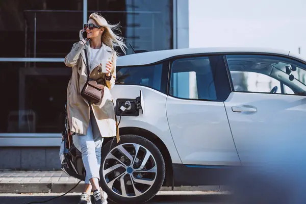 Woman charging electro car at the electric gas station