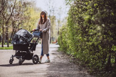 genç anne ile bebek arabası Park yürüme