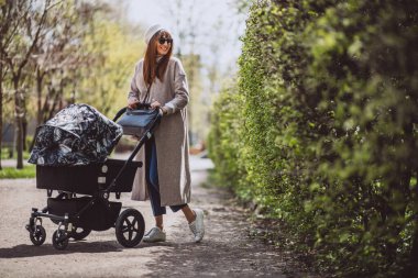 genç anne ile bebek arabası Park yürüme