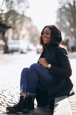 Sokakta manto giyen Afrikalı Amerikalı kadın.