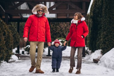 Anne ve baba oğluyla birlikte kışın dışarıda.