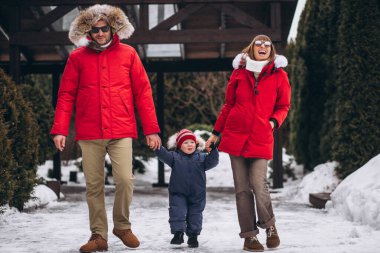 Anne ve baba oğluyla birlikte kışın dışarıda.