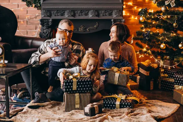 Noel arifesinde Noel ağacının hediyeleriyle büyük bir aile.