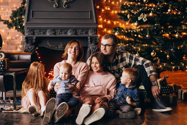 Noel arifesinde Noel ağacının hediyeleriyle büyük bir aile.