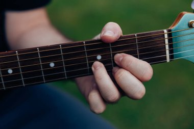 Akustik gitar çalan adamın elini kapat. Eğlence ya da hobi tutku konsepti için müzik aleti
