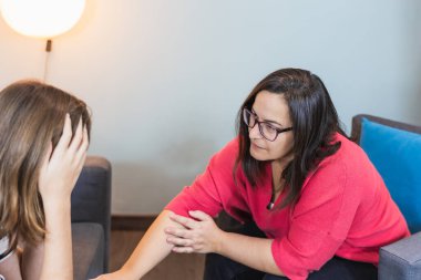 Kadın psikoterapist, ergen hastasını terapide teselli ediyor. Eşlik ve ruh sağlığı kavramı