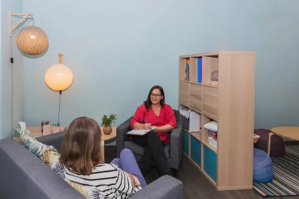 stock image Woman psychotherapist smiling and attending to her adolescent patient in therapy. Concept of accompaniment and mental health