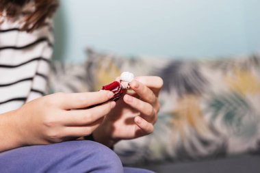 Guadalajara, İspanya - 12 Ekim 2023: Terapide bebeklerle yapılan aile yapılandırması çalışmaları için kullanılan bir bebeği olan ergen bir kızın eli. Terapi ve akıl sağlığı kavramı