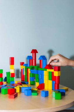 Terapi seansında renkli tahta bloklarla oynayan ergen bir hastanın eli. Terapi ve akıl sağlığı kavramı