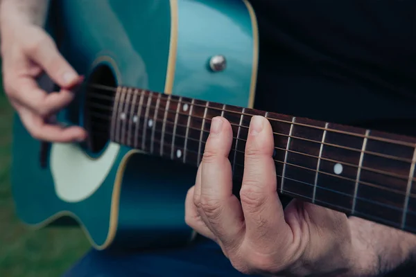 Akustik gitar çalan adamın ellerini kapat. Eğlence ya da hobi tutku konsepti için müzik aleti