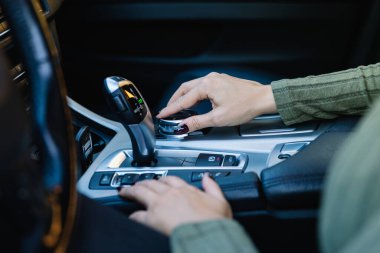 Kadın elinin üst düzey otomatik arabasının kumandalı joystick 'ini kullanmasını kapat. Sürücü kavramı ve araç ekipmanı