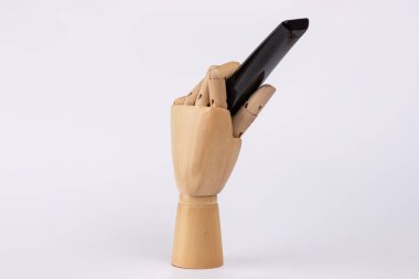 Tahta el beyaz arka planda siyah televizyon uzaktan kumandasını tutuyor. Uzayı kopyala Eğlence, televizyon ve uzaktan kumanda kavramı