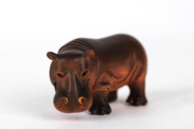 Beyaz arka planda izole edilmiş kahverengi plastik bir su aygırı. Yarı suda yaşayan memeli hayvanlar kavramı