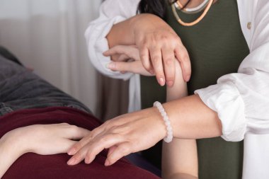 Close-up shot of the hands of a female therapist performing acupressure on a patient. Concept of pna, therapy, psychotherapy, kinesiology and acupressure clipart