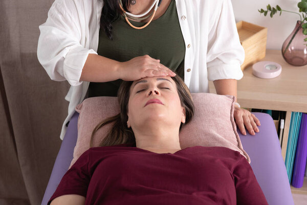Крупный план сверху на пациентку за 40, которая проводит сеанс акупрессуры со своим психотерапевтом. Концепция терапии, оздоровления, психотерапии, кинезиологии и акупрессуры