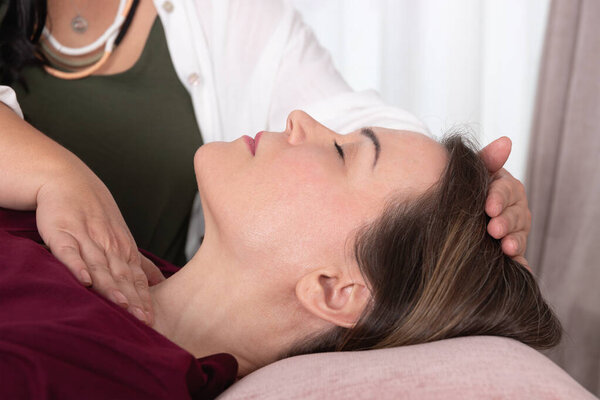 Крупным планом женщина за 40, получающая точечную терапию из рук своего терапевта. Концепция терапии, оздоровления, психотерапии, кинезиологии и акупрессуры