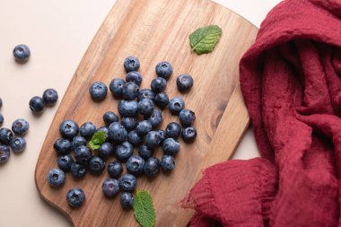 Nane ve kırmızı kumaşlı yaban mersinlerinin kırsal panoda görüntüsü. Yumuşak ışıklandırma ve minimalist altyapı. Beslenme, tazelik ve doğal besin kavramı