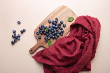 Kesme tahtasındaki kırmızı kumaş ve nane aromalı yaban mersini manzarası. Hassas ışıklandırma. Uzayı kopyala Dengeli gıda, tazelik ve köy tarzı kavramı