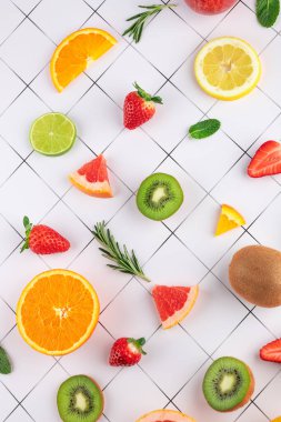 Siyah çizgileri olan beyaz yüzeydeki tropikal ve taze meyvelerin üst görüntüsü. Parlak bir üst görünüm. Doğal ve organik gıda konsepti