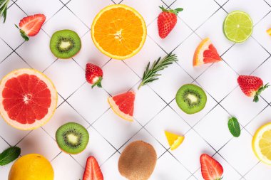 Beyaz yüzeyde, siyah ızgaralı çeşitli meyvelerin bileşiminin yukarıdan görüntüsünü al. Temiz ve düzenli bir tasarım. Taze ve doğal gıda konsepti