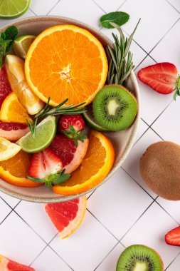 Dilimlenmiş taze ve canlı meyveler arasında narenciye, çilek, kivi, portakal, greyfurt, nane ve biberiye de var. Tazelik ve sağlıklı yaşam kavramı