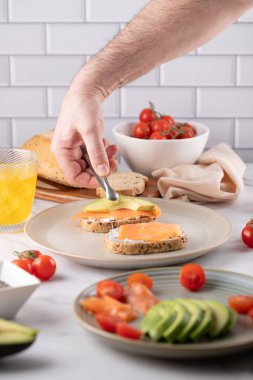 Erkek Elleri Somon Tostuna Avokado Dilimi Yerleştiriyor. Taze Sağlıklı Ev Yemeği