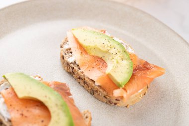 Avokado, somon ve krem peynirli sağlıklı tost ekmeği. Dengeli ve doğal beslenme. Sağlıklı kahvaltı kavramı