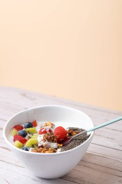 Sağlıklı kahvaltıda kefir, taze meyve, kivi, chia tohumu ve yumuşak bir zemin üzerinde granola. Kopyalama alanı olan minimalist kompozisyon. Dengeli ve modern yemek için ideal. Sağlıklı kahvaltı kavramı 