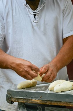 Fırıncı geleneksel ekmek pişirme, vitrin işçiliği ve aşçılık uzmanlığı için hamur hazırlıyor.