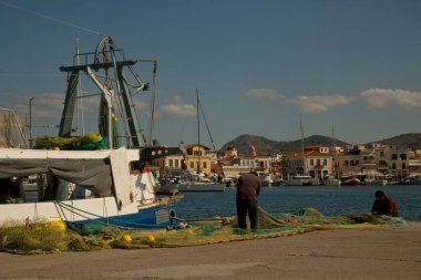 AEGINA, GREECE. 29 Ekim 2021 'de. Yunanistan 'ın Aegina adasında balıkçılar ağı onarıyor.