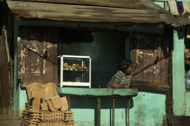 ANTANANARIVO, MADAGASCAR, 22 Haziran 2023. Antananarivo, Madagaskar 'daki bir sokak kafesinin penceresinden bir çocuk bakıyor..