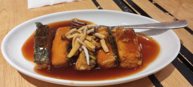 Shimeji mantarı soslu ve arka planda beyaz tabakta.