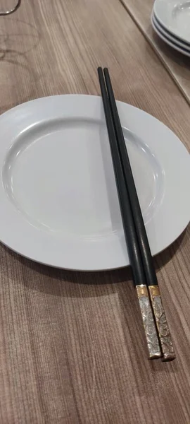木桌上的白盘和筷子 — 图库照片
