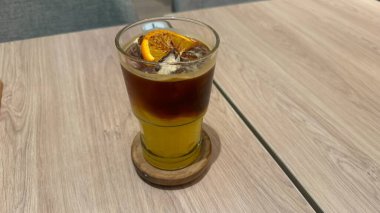 Limonlu buzlu kahve ve tahta masada buz.