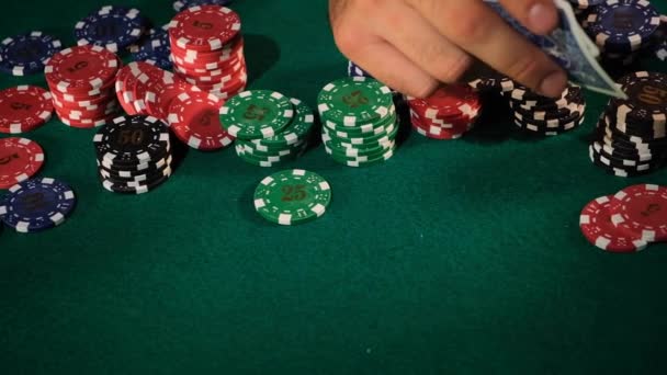 纸牌游戏中的一个人的手 在一张绿卡桌上摆出一对王牌 上面放着他们的薯片和饮料 — 图库视频影像