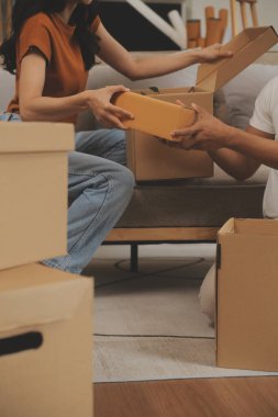 Güzel, genç ve aşık bir çift yeni dairelerine taşınırken karton kutulardan bir şeyler çıkarırken eğleniyorlar.