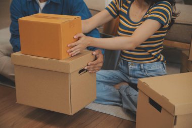 Güzel, genç ve aşık bir çift yeni dairelerine taşınırken karton kutulardan bir şeyler çıkarırken eğleniyorlar.