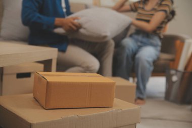 Güzel, genç ve aşık bir çift yeni dairelerine taşınırken karton kutulardan bir şeyler çıkarırken eğleniyorlar.